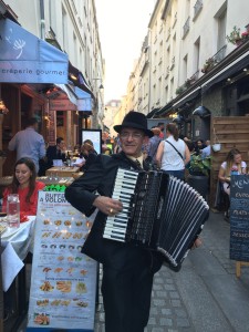 Man in black suit playing accordion on street in Paris 