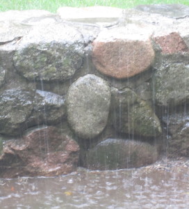 A photo of rain falling on a stone wall